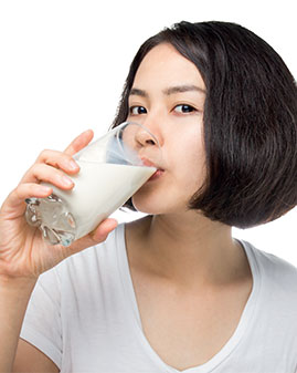 A photo of a young woman drinking milk