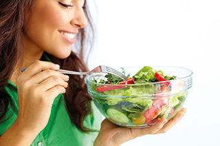 A photo of a woman with a bowl of salad